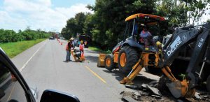 Operadores trabajan con equipos John Deere en una carretera.